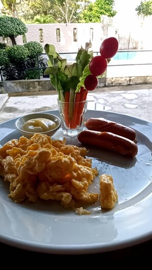 A plate with scrambled eggs, sausages, and a small salad with radishes and lettuce. - Blue Orchid Beach Krabi (Krabi)