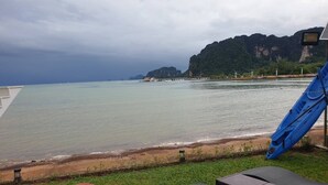 A beachside view with a kayak, lounge chairs, and a red ball. - Blue Orchid Beach Krabi (Krabi)