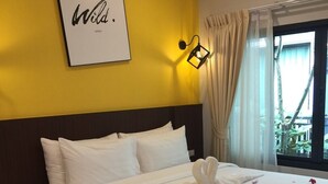 A neatly made bed with white linens and a towel, a framed quote on the wall, and a window with curtains. - Blue Orchid Beach Krabi (Krabi)
