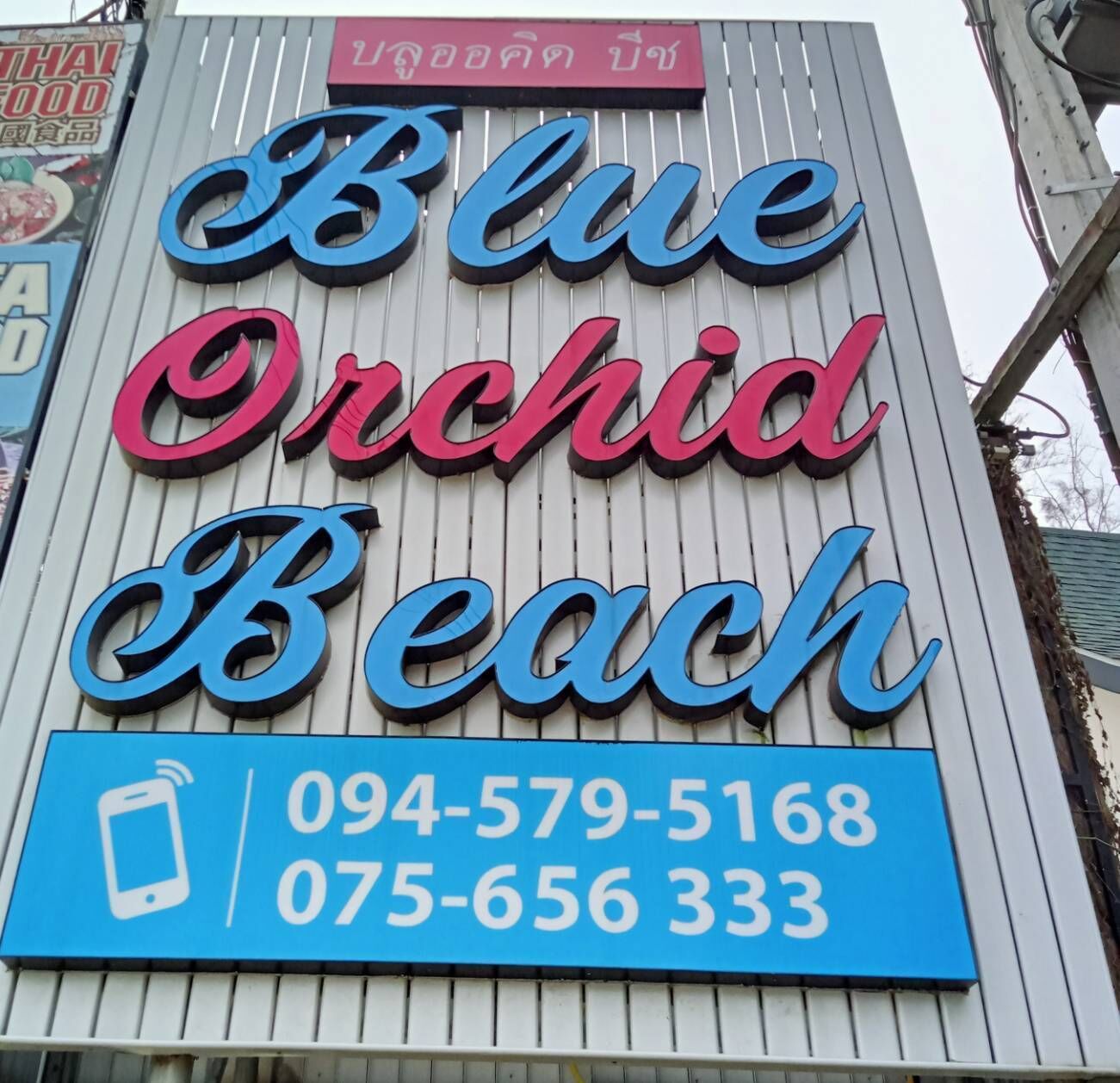 Señal de Blue Orchid Beach con números de contacto.
