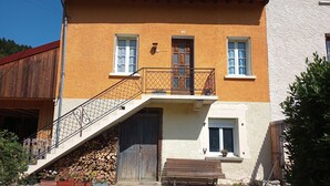 Un bâtiment à deux étages doté d’un escalier en bois, d’un balcon et d’un banc en bois à l’extérieur.