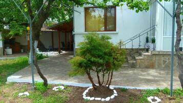 Enjoy the serene garden and outdoor living space with a wooden deck and stone pathway.