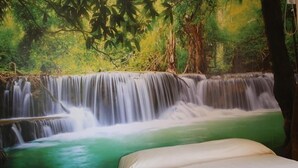 A room with a mural of a waterfall, a bed, and a window. - La Casa dell'Orso (Ciampino)