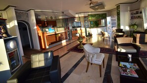 Un amplio salón con chimenea, asientos cómodos, televisor y zona de comedor con barra.