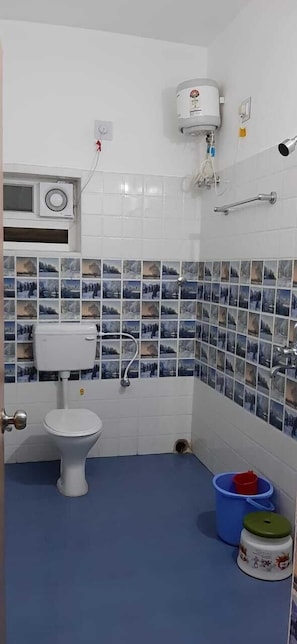 A bathroom with a toilet, a shower, and a sink.