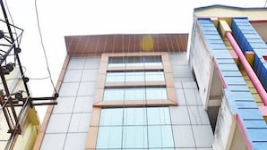 A building with a sign reading "Nirmala Residency" and a wooden door with glass panels. - Hotel Nirmala Residency (Bhubaneshwar)