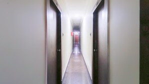A narrow hallway with doors on both sides, leading to a room at the end. - Hotel Nirmala Residency (Bhubaneshwar)