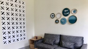 A modern living room with a grey sofa, a wooden coffee table, and decorative plates on the wall.