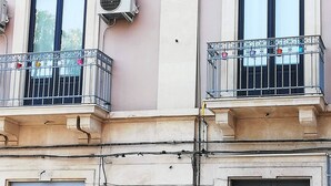Ein Gebäude mit zwei Fenstern, jedes mit einem Balkon und einer an der Wand befestigten Klimaanlage.