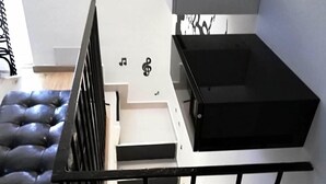 Eine moderne Küche mit schwarzem Arbeitsplatz, einem weißen Schrank und einer Treppe mit schwarzen Geländern.