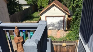 Eine Holzterrasse mit einem Stuhl und einer Statue.
