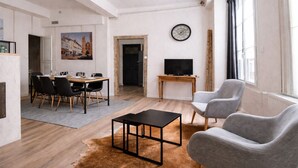 Un salon moderne comprenant un coin repas, un téléviseur et une horloge murale.