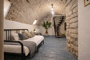 A bedroom with a bed, a potted plant, a radiator, and a staircase. - Historic center of Chalon-sur-Saône, Burgundy cellar, 8 pers, parking nearby (CHALON SUR SAONE)