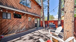Puinen mökki, jossa on terassi, ulkotila istumiseen ja grillauspaikka.