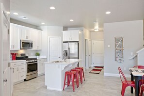 Enjoy cooking in this well-lit kitchen with a central island, stainless steel appliances, and a cozy seating area.