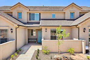 Stylish two-story residence with a flat roof and central entrance, flanked by windows with shutters.