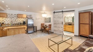 Una cocina moderna con armarios de madera, un refrigerador y un comedor con mesa y sillas.