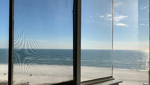 Una habitación con un ventanal grande con vistas a la playa.