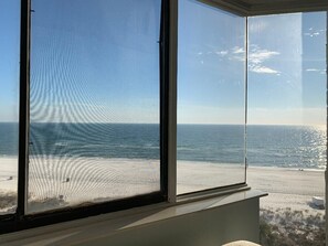 Quarto com uma grande janela com vista para a praia.