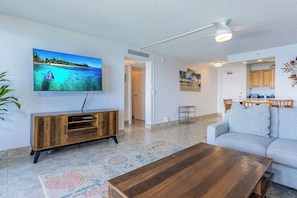 A living room with a TV, sofa, coffee table, and a wooden cabinet.