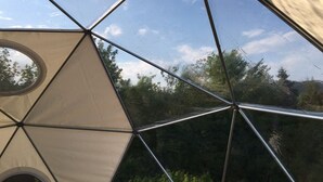Una estructura de domo geodésico con ventanal circular y armazón metálico.