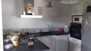 Eine moderne Küche mit schwarzem Arbeitsplatz, Edelstahlgeräten, einer Mikrowelle und einer Kaffeemaschine.