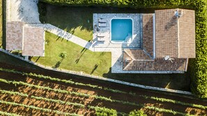 Luftaufnahme eines Anwesens mit Schwimmbad, Außenbereich zum Sitzen und einem Weinberg.