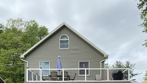 A two-story house with a covered deck and a small front porch.