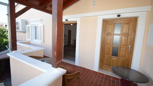 Un espacio al aire libre cubierto con una mesa, una puerta y vistas al interior.