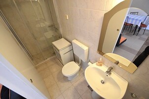 Un baño con inodoro, lavamanos y ducha.
