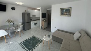 Ett modernt vardagsrum med en soffa och en matplats med stolar och ett bord.