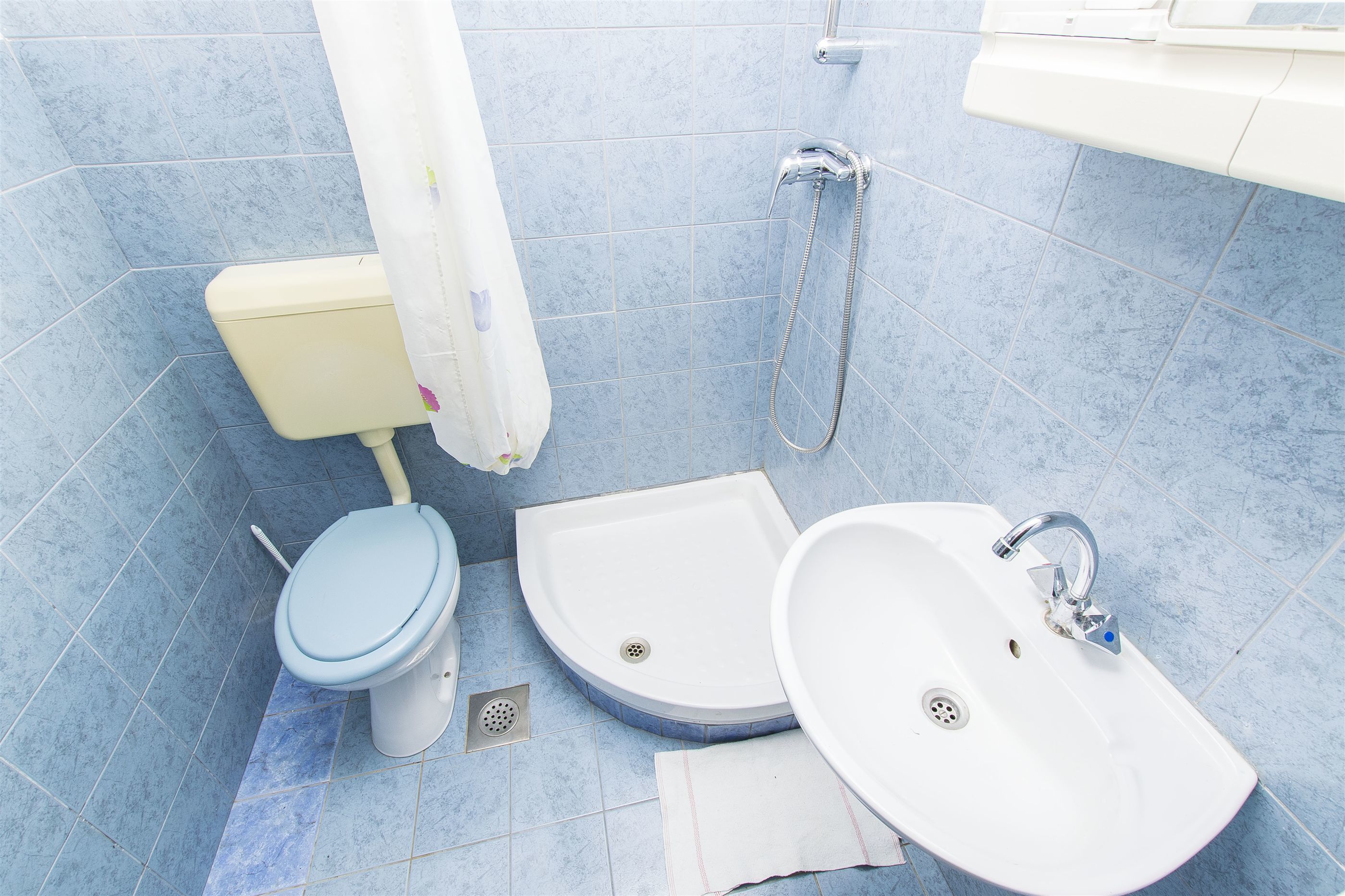 Een badkamer met toilet, wastafel en douche.