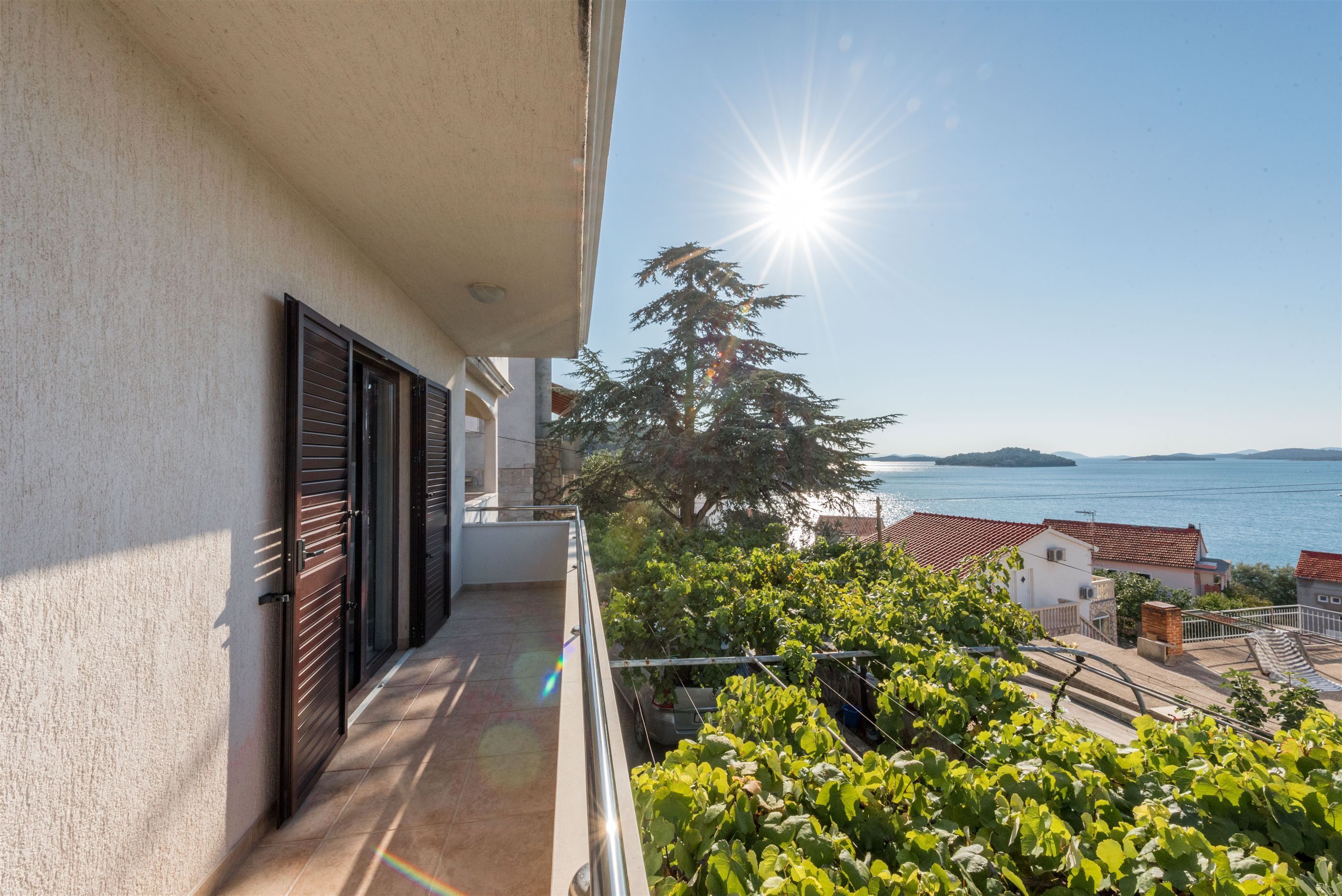 Un balcone con vista sul mare e un albero.