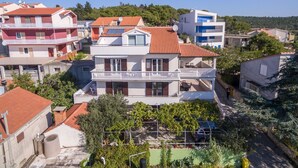 Un immeuble résidentiel doté de nombreux balcons, d’un jardin sur le toit et offrant une vue dégagée sur le quartier environnant.