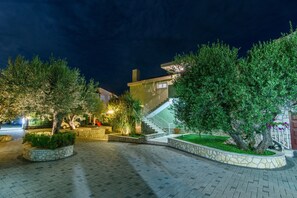 A paved courtyard with stone planters, a staircase, and a building with a visible entrance.