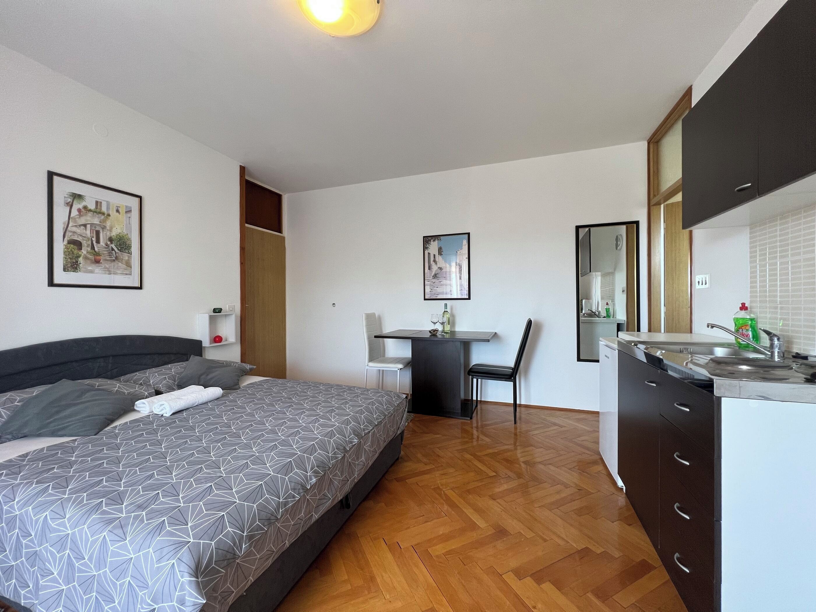 Une chambre comprenant un lit, un bureau et une kitchenette.