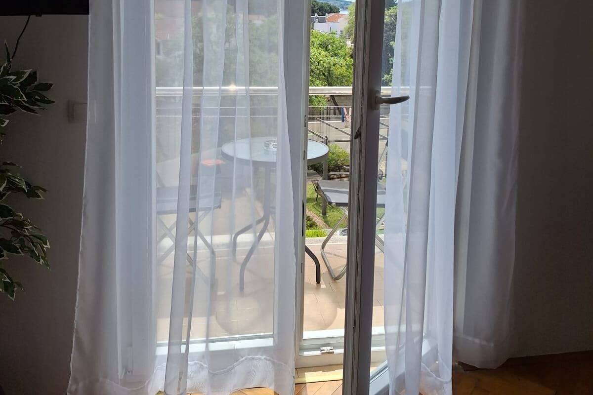 A room with a sliding glass door leading to an outdoor patio with a table and chairs.
