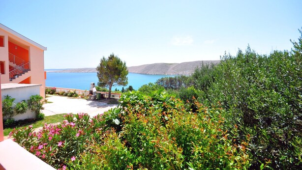 A modern building with a balcony overlooking a clear blue sea and hills. - Apartments Andelo (Vlasici)