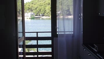 An open door to a room with a view of a lake and a bridge.