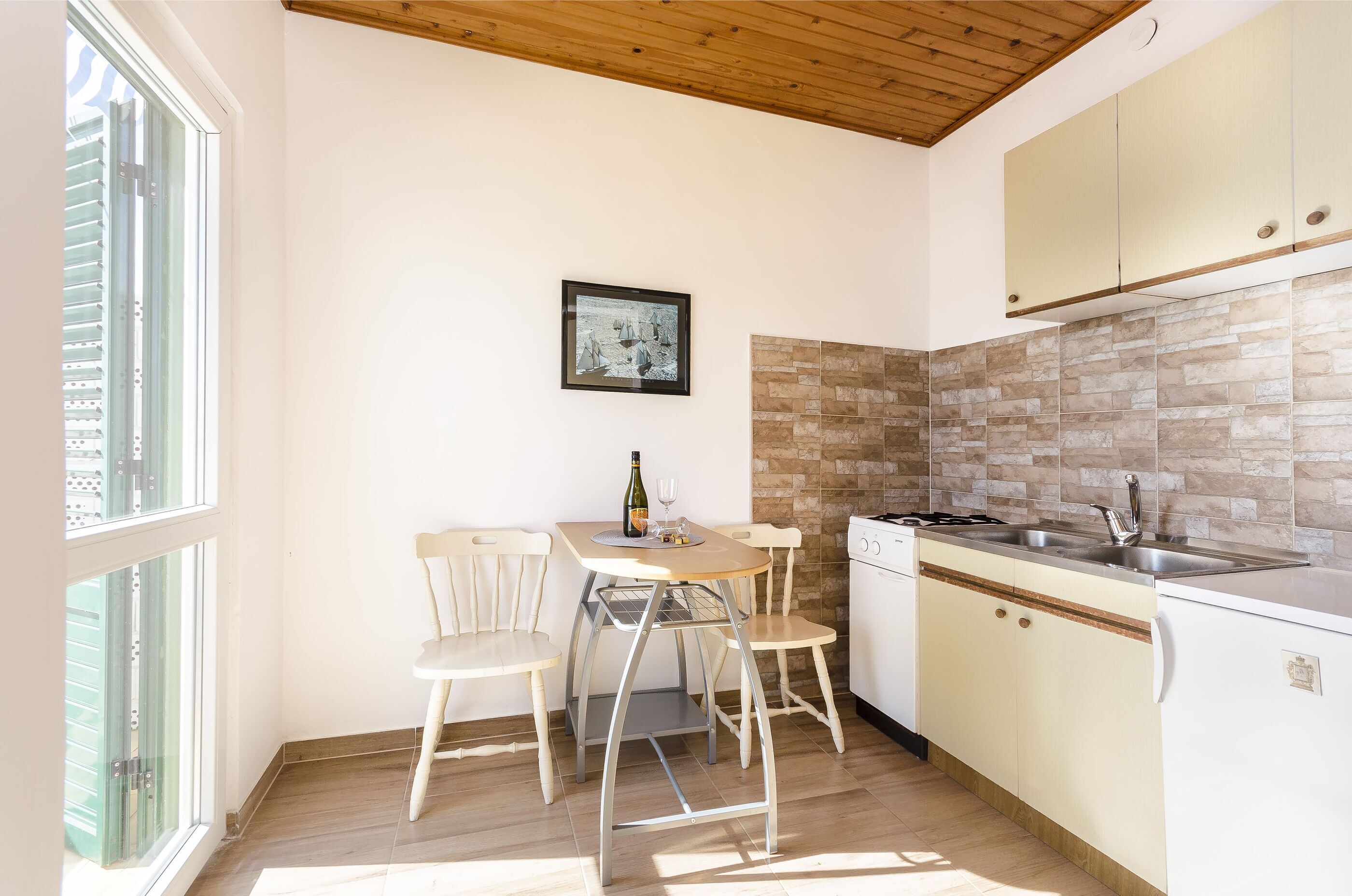 Une cuisine équipée d’une table à manger, de chaises, d’un évier et d’une cuisinière.