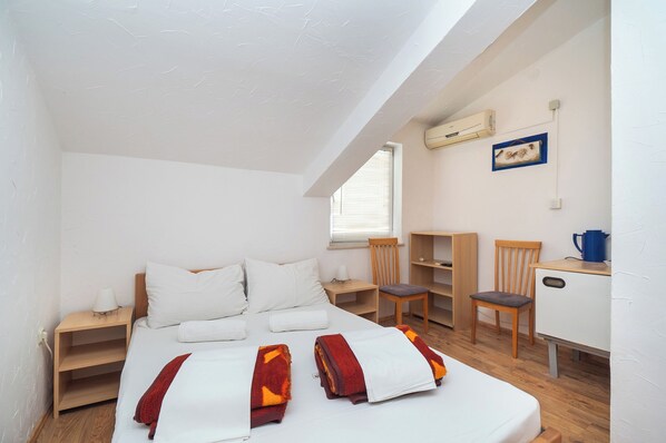 Ein Schlafzimmer mit einem großen Bett, einem Schreibtisch, einem Stuhl und einem kleinen Schrank.