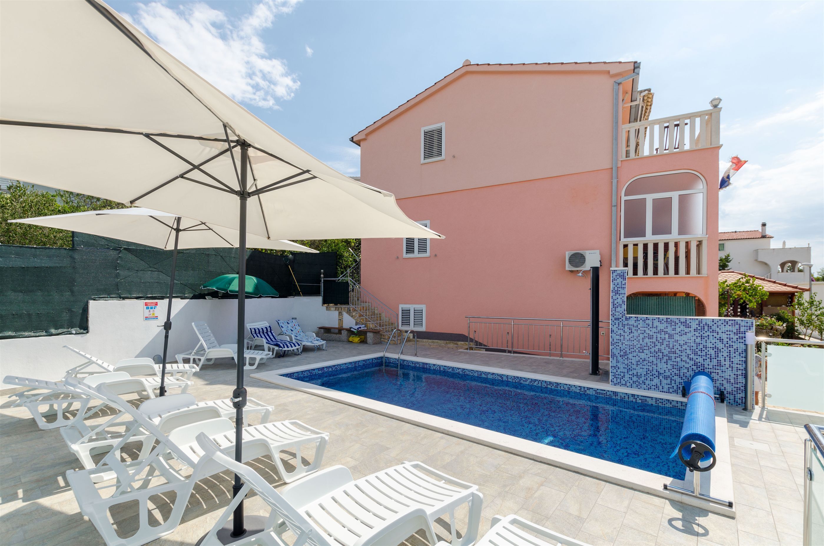 Una piscina al aire libre, sombrillas