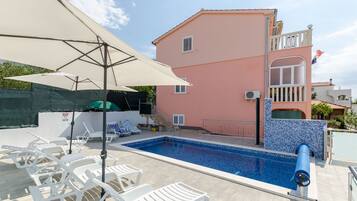 Una piscina al aire libre, sombrillas
