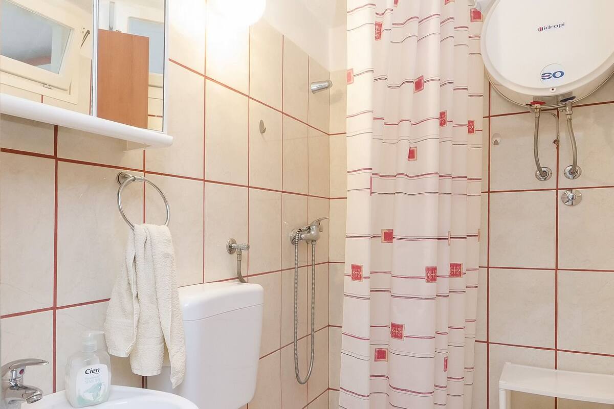 Ein Badezimmer mit Toilette, Waschbecken, Dusche und Spiegel.