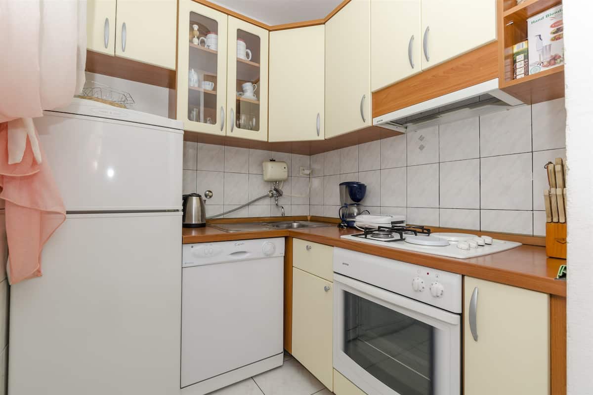 Una cocina compacta equipada con lavavajillas, horno y cafetera.