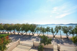 A coastal promenade with trees lining the path, a clear sky, and a calm sea in the background. - Apartment Srima (Srima)