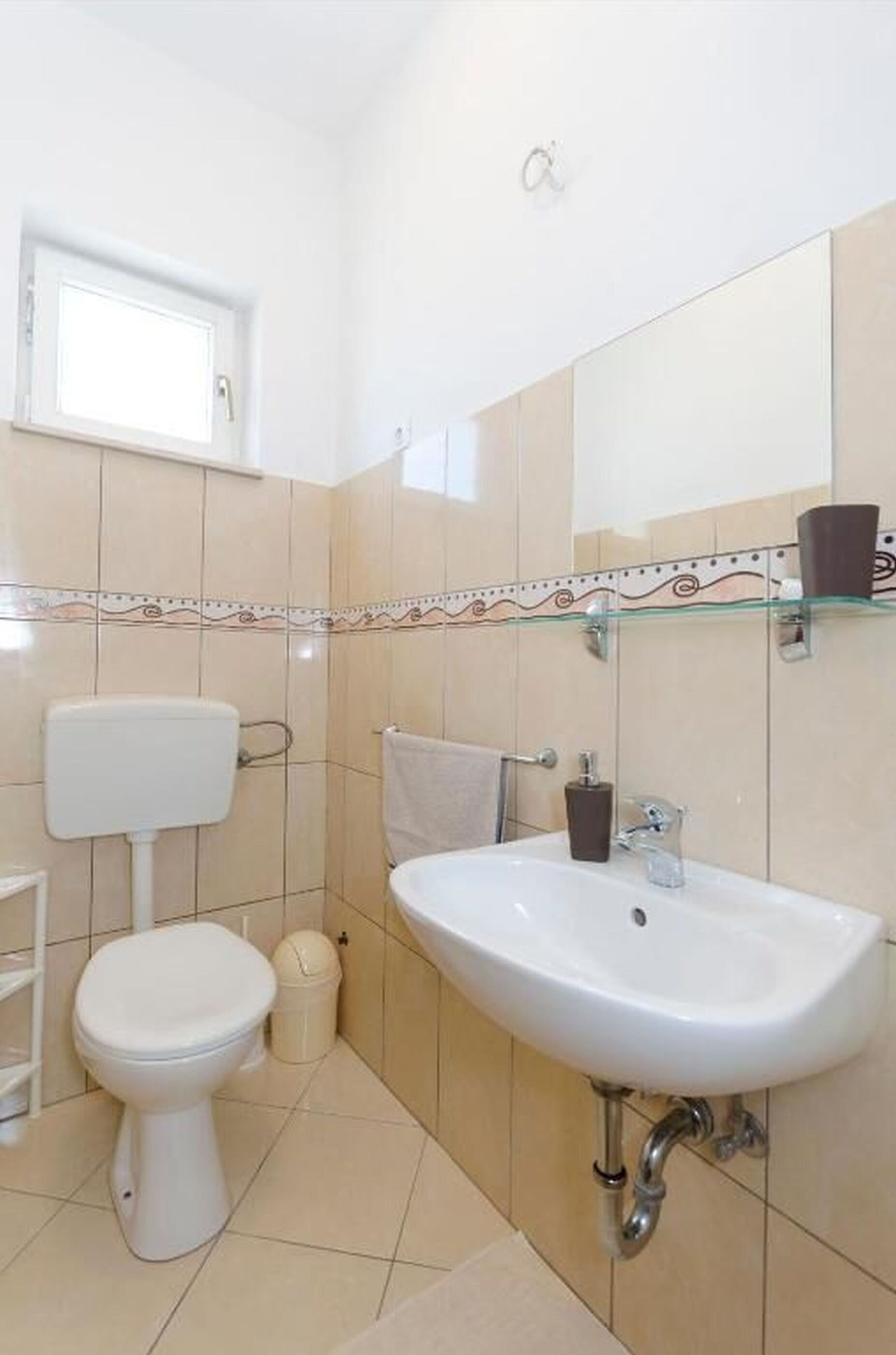 Un bagno con il water, lavandino e specchio.