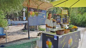 Een sapkraam met een bord waarop staat 100% natuurlijk sap en smoothies.