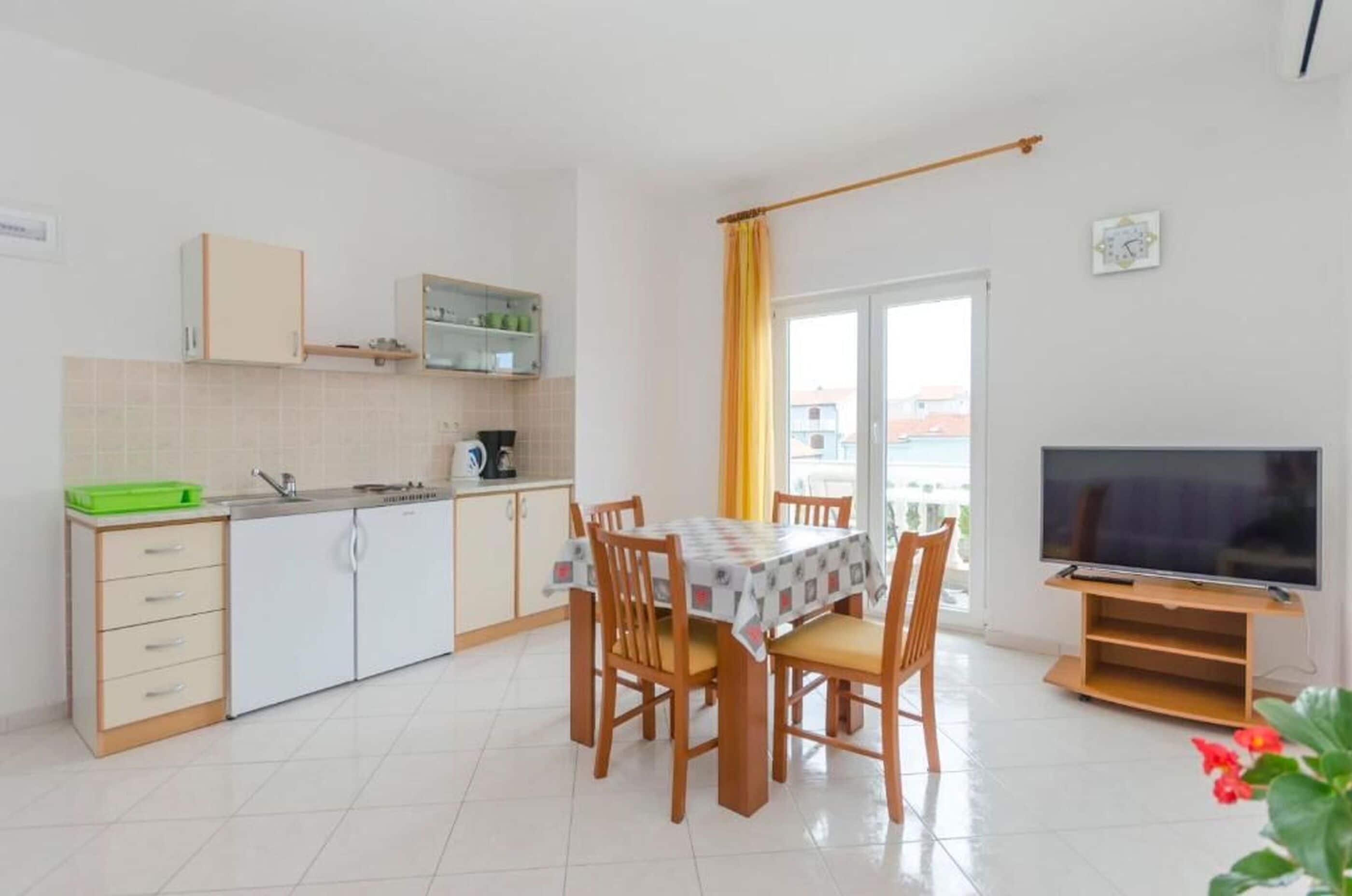 Een knus woongedeelte met een kitchenette, een eethoek en een televisie.
