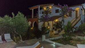 A two-story building with a balcony, outdoor seating area, and a staircase. - Apartment Piveta (Okrug Gornji)